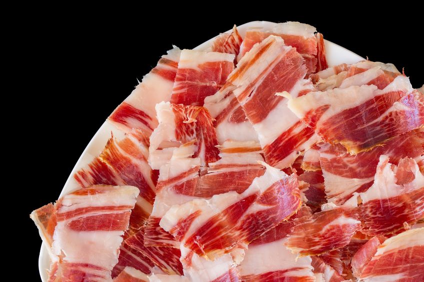 Plato de jamón ibérico de tonos rojizos.