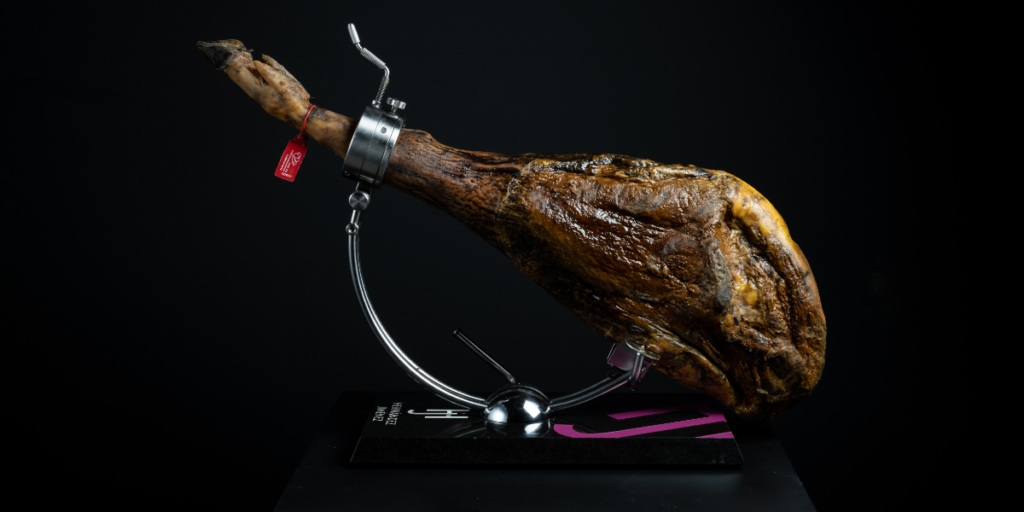 Jamón ibérico colocado en un jamonero listo para cortar y acompañar con vino
